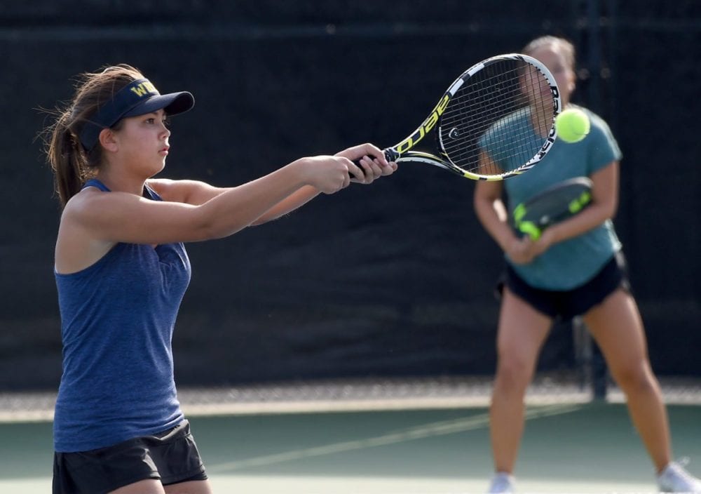 West Ranch High's Emily Andrews hits the ball as partner Audrey Kim plays the back court in their second-round doubles match against Valencia during day one of the Foothill League girls tennis individual tournament at the Paseo Club. Photo by Jayne Kamin-Oncea/For The Signal