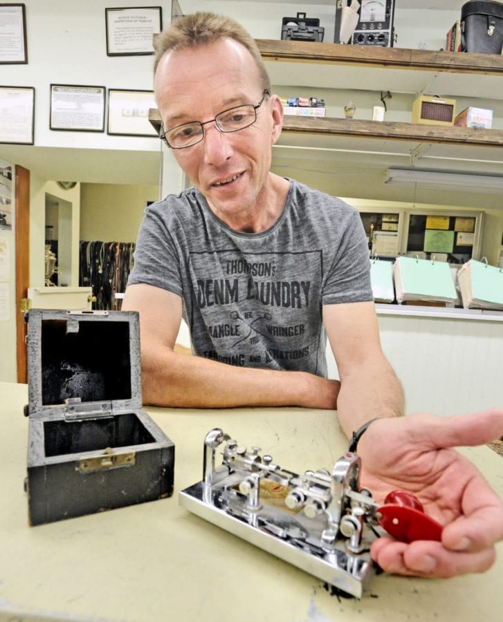 Abe's Pawn Shop owner Thomas Bayer displays a vintage Morse code key from 1936. Dan Watson/The Signal