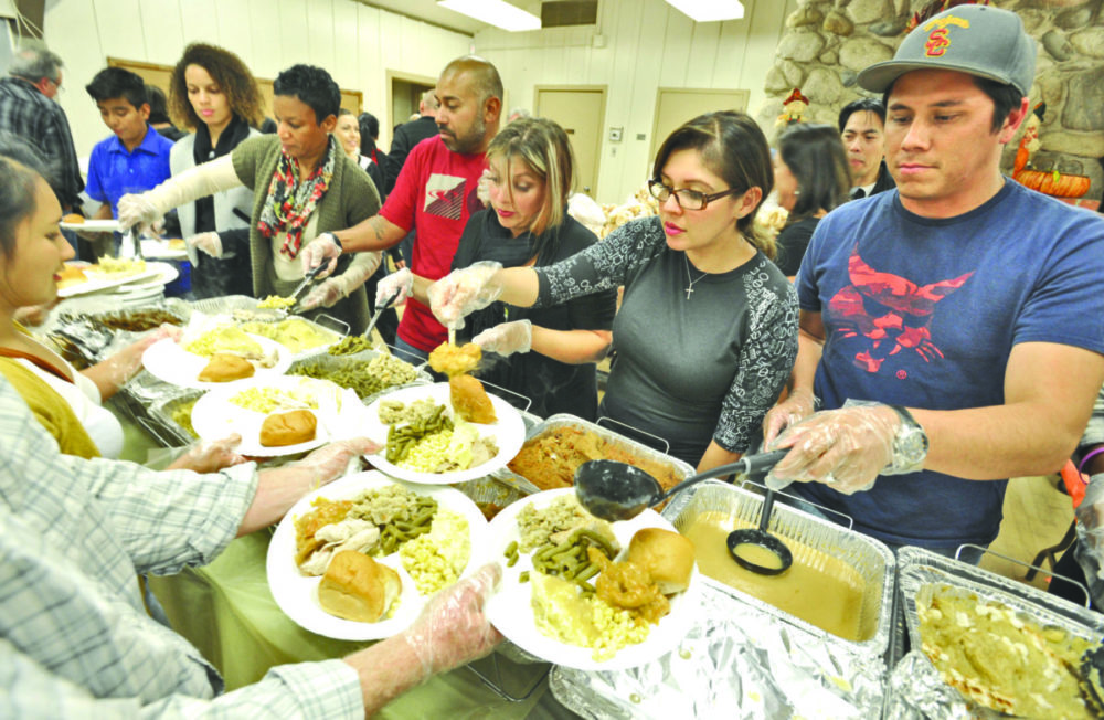 Some of the 80 Real Life Church volunteers serve up plates of Thanksgiving dinner for the 450 attendees of the Val Verde community at the Val Verde Recreation Center.  Dan Watson/The Signal