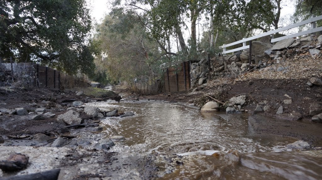 Water, mud and debris flows downhill in a trench along Iron Canyon Road on Sunday after Friday night's storm causes mudslides in the Sand Canyon areas. Samie Gebers/ The Signal