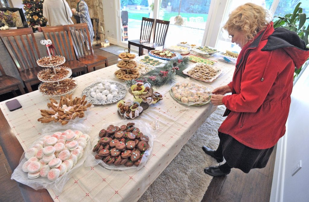 Evelyn Taibi places her four-dozens cookies on the table at Lynn Parkinson's 50th Annual Cookie Exchange in Sand Canyon on Saturday. Dan Watson/The Signal