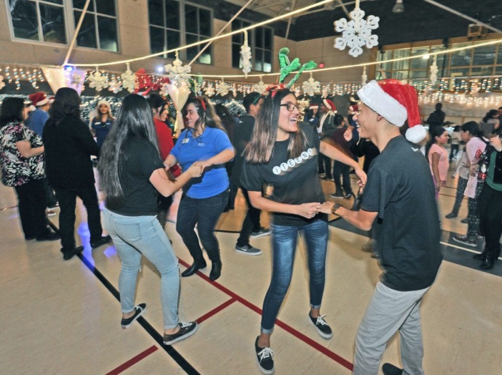 Dozens of attendees dance to the DJ's music at the at the Newhall Community Center's Holiday Family Party in Newhall on Friday. Dan Watson/the Signal