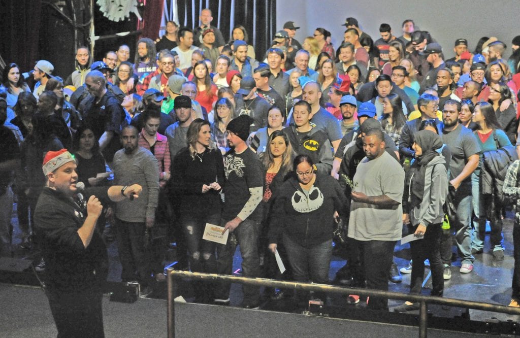 Group Sales Manager Gavin Grozier, left, points to the exit after the more than 100 couples gathered on stage at the Gearworks Theater at Six Flags Magic Mountain in Valencia to participate the seven, Six Flags theme park attempt to break the Mistletoe Kiss Record on Saturday. Dan Watson/The Signal