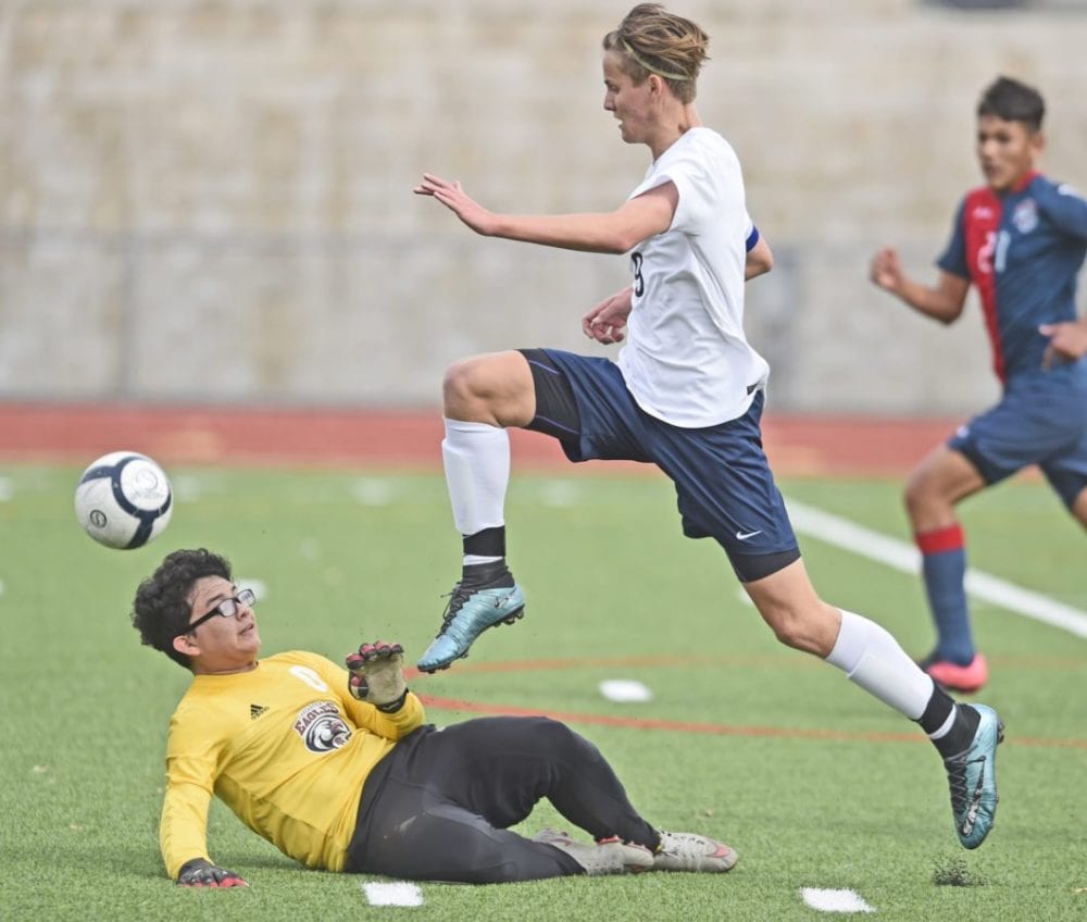 Saugus forward James Johnson (9) runs over Lancaster goal keeper Darwin Chavez to make a shot on goal in the first half at Saugus High School on Tuesday. Dan Watson/The Signal