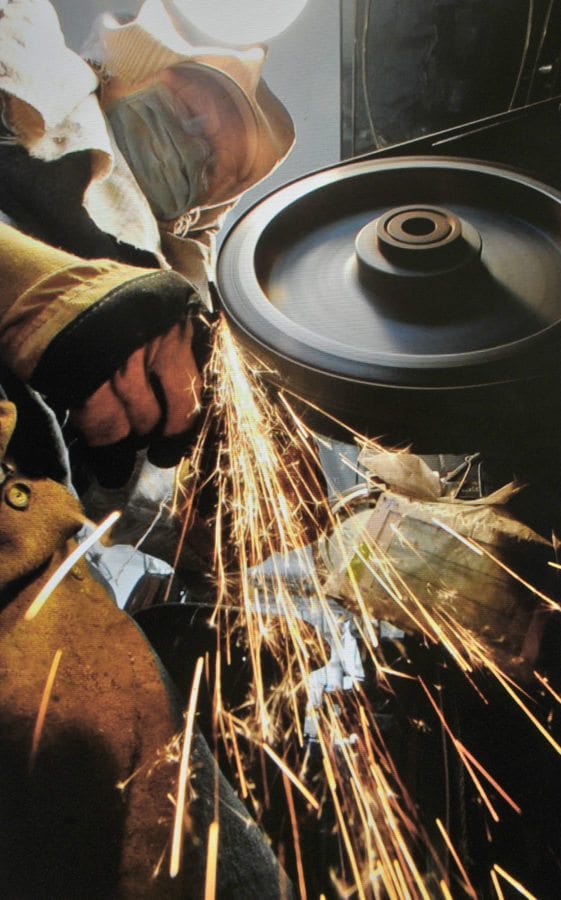 Sparks fly as Bill Herndon shapes a blade using one of six grades of sandpaper on a grinding wheel. Dan Watson