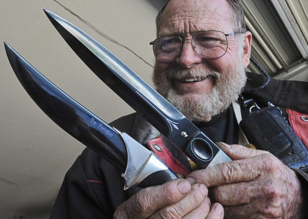 Bill Herndon displays two of his high art knives which would command more than $2,000 dollars each. The Persian style dagger on the left, has his name engraved in the blade and five ounces of silver, the knife on the right has silver inlay and mother of pearl handles. Dan Watson