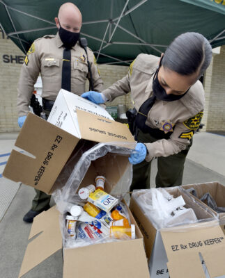 Santa Clarita Valley Sheriff's Station Deputy Nelson, left, and Detective Nashla Barakat, of the station's Juvenile Intervention Team, box up drugs that were dropped off during a previous drug take-back day event at the SCV Sheriff's Station.