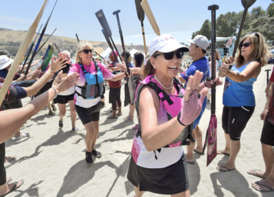 Members of the "Phoenix Desert Dragons", dragon boat team, who are all cancer survivors and dressed in pink, are celebrated with an oar bridge gauntlet after competing during the 3rd Annual Castaic Lake Dragon Beat Festival held at Castaic Lake in Castaic on Saturday, 060422. Dan Watson/The Signal