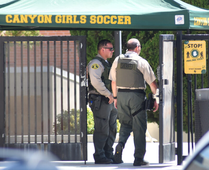 Santa Clarita Valley Sheriff's Station deputies guard an exit after responding to a stolen vehicle and possible gun on campus at Canyon High School in Canyon Country on Wednesday, 081722.