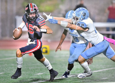 Saugus High defensive players Dario Sandoval (82) and Deohn Turner (0) pressure Hart quarterback Timmy Larkings (16) in the first quarter at College of the Canyons on Friday, 100722. Dan Watson/The Signal