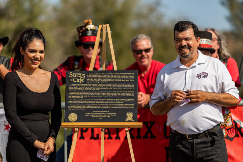 Jesse Mercado and her father Alfredo Mercado, the owner of the Original Saugus Cafe, are awarded with the plaque by the E Clampus Vitus Platrix Chapter #2 and Peter Lebeck Chapter #1866 for being the oldest operating cafe in Los Angeles County in the parking lot of the cafe on Sunday, Oct. 17, 2022. Chris Torres/The Signal