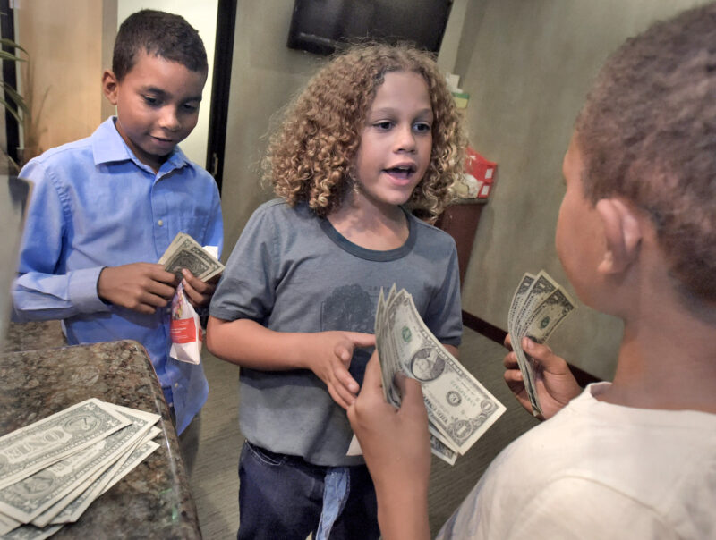 Triplets, from left, Wyatt, Shelby and Ellis Sosthand, 10, divide their cash after trading in their candy during the Halloween candy buy back and Letter Writing Campaign & Kids Karnival event held at Santa Clarita Advanced Dentistry in Santa Clarita on Tuesday, 110122.  