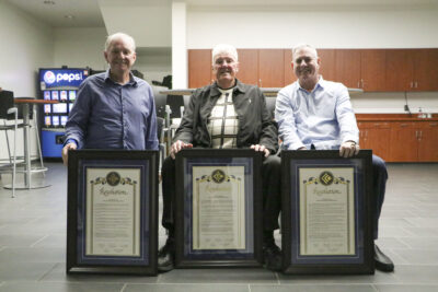 (From left) Dr. Greg Jenkins, husband of recently passed longtime board member Michele Jenkins, Lee Smelser, the first men's basketball head coach in College of the Canyons history, and Mitch Gillespie, son of former COC baseball head coach Mike Gillespie, received board of trustee resolutions officially approving the naming of COC athletic facilities in their name. The West P.E. Gymnasium will be renamed Lee Smelser Court; the baseball facility will be named Mike Gillespie Field; and the softball program's team room becomes the Michele Jenkins Team Room. Courtesy photo.