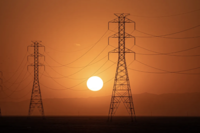 The sun sets behind a row of electric towers in Fresno County on Sept. 6, 2022. Photo by Larry Valenzuela, CalMatters/CatchLight Local