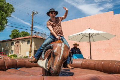 James Fairbanks IV rides the mechanical bull at the 2023 Cowboy Festival on Main Street in Old Town Newhall, Calif., on Saturday, April 22, 2023.