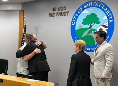 Jaime Puerta, president of the Victims of Illicit Drugs, receives a hug Tuesday from Santa Clarita Mayor Jason Gibbs during the city's second annual recognition for National Fentanyl Prevention and Awareness Day as council members Laurene Weste and Cameron Smyth look on. Perry Smith/ The Signal