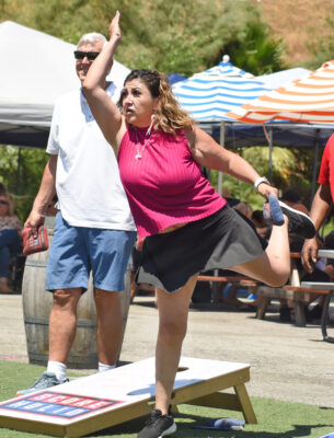 Carolina Orozco tosses her bean bag as 28 teams compete for the $500 top prize during the inaugural Samuel Dixon Family Health Center Cornhole Tournament Fundrasier held at Kucky Luke Brewing in Santa Clarita on Saturday, 081223. Dan Watson/The Signal