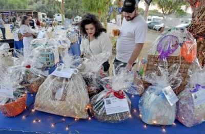 Attendees Jilliann and Riley Miracle examine the items in the silent aution during the Sulphur Springs Community School "Mustang Roundup" event held at River's End RV Park, Pub and BBQ in Santa Clarita on Saturday, 100723. Dan Watson/The Signal