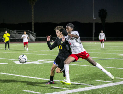 Canyon midfielder Mason Ortiz (23) fights for the ball on the sideline against Hart's Messiah Antwi (4) during the first half of Tuesday's game at Canyon High School. Habeba Mostafa/ The Signal