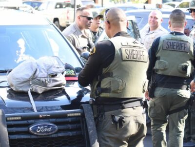 Santa Clarita Valley Sheriff's Station deputies search the backpack of a suspect who was reportedly apprehended following a brief foot pursuit Tuesday morning near the Interstate 5 freeway. Dan Watson/The Signal.