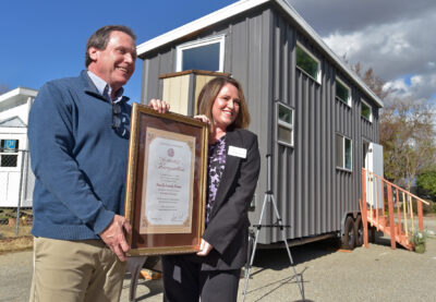 California State Senator Scot Wilk, left, presents his non-profit of the first quarter award to Finally Family Homes Founder and Executive Director Christina Dronen in front of one of the organization's new "tiny homes" during a ceremony on Friday in Santa Clarita, 020224. Dan Watson/The Signal