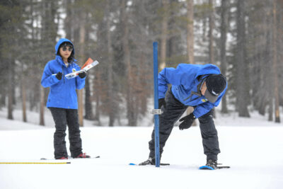 (Left to right) Angelique Fabbiani-Leon, State Hydrometeorologist and Andy Reising, Water Resources Engineer, both from the California Department of Water Resources Snow Surveys and Water Supply Forecasting Unit, walks in the deep snow during the measurement phase of the third media snow survey of the 2024 season at Phillips Station in the Sierra Nevada Mountains. The survey is held approximately 90 miles east of Sacramento off Highway 50 in El Dorado County. Photo taken February 29, 2024.