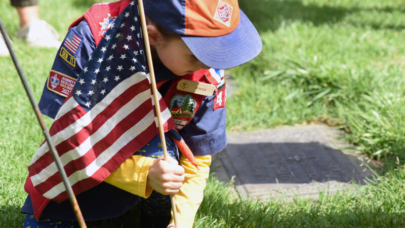 Tiger Scout, Alexis Carden, 7, places a flag on the grave of a veteran at Eternal Valley Memorial Park and Mortuary in preparation for Memorial Day in Newhall on Saturday, 052524. Dan Watson/The Signal