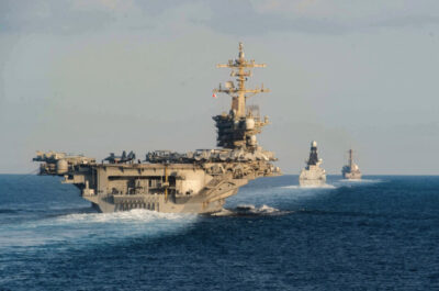 The aircraft carrier USS Abraham Lincoln (CVN 72) (L) the Royal Navy air defense destroyer HMS Defender (D 36), and the guided-missile destroyer USS Farragut (DDG 99) transit the Strait of Hormuz in this handout photo on Nov. 19, 2019. U.S. Navy photo by Zachary Pearson.