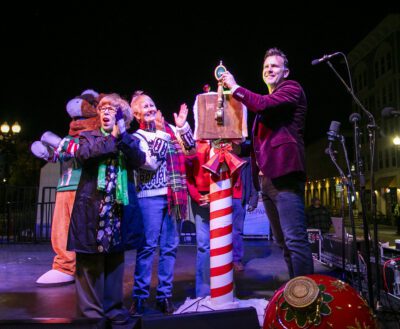 Sammy Clarita, left, Councilwoman Marsha McLean, center left, Councilwoman Laurene Weste, center right, and Mayor Cameron Smyth flip the switch to light the tree during Light Up Main Street in Old Town Newhall on Saturday, Nov. 16, 2024. Habeba Mostafa/ The Signal