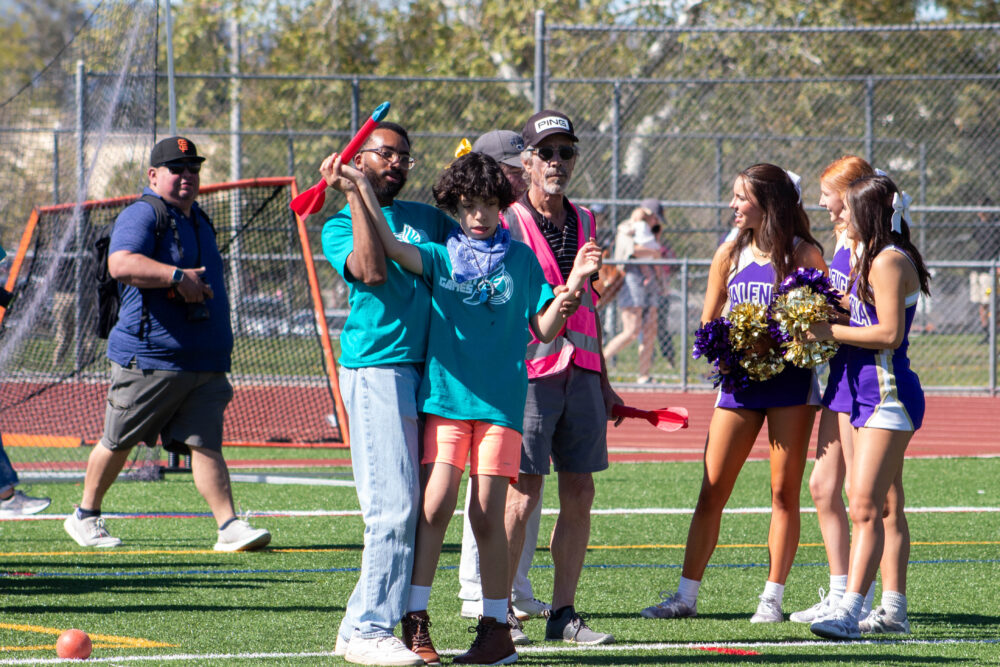La Mesa Junior High School instructional assistant Christian Paisley helps Aiden Van Elslande throw a javelin at the 13th annual Hart Games track and field meet hosted at Valencia High School on Monday morning, March 24, 2025. Maya Morales/The Signal