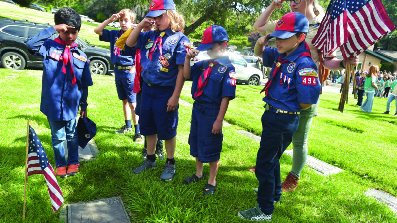 Cub Scouts from Troop 494 of Canyon Country salute a flag they placed on the grave of a veteran at Eternal Valley Memorial Park and Mortuary in preparation for Memorial Day last year. SIGNAL FILE PHOTO