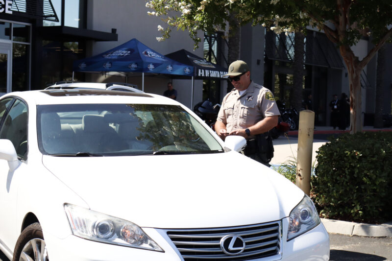 Deputy Keith Wells speaks to attendees before he rabs their paperwork at the Santa Clarita Valley Sheriff’s Station Catalytic Converter Etching Event in Valencia, Saturday, July 19, 2025. Kamryn Martell/The Signal