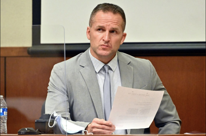 Former Louisville Police officer Brett Hankison examines a document as he answers questions from the prosecution, in Louisville, Ky., on March 2, 2022. Pool photo by Timothy D. Easley/via AP Photo