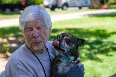 Dee Powers is caught by surprise after Rocky, her new 7 year old pug, licks her in the face before she takes him home following the pet adoption event at Bridgeport Park on July 24, 2025 in Valencia, Calif. Katherine Quezada/The Signal