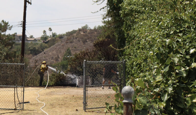 First responders hose down the backyard after a spot fire on the 27200 block of Seco Canyon Road, Monday, August 4, 2025. Kamryn Martell/The Signal