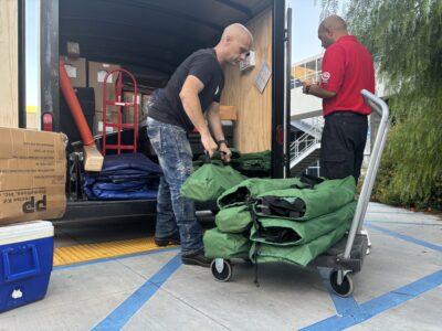 From left: Scott Kwiatrowski and Shawn Sangeladji of the American Red Cross unload cots for the evacuation center at College of the Canyons in Valencia, Aug. 7, 2025. Michael Picarella/The Signal