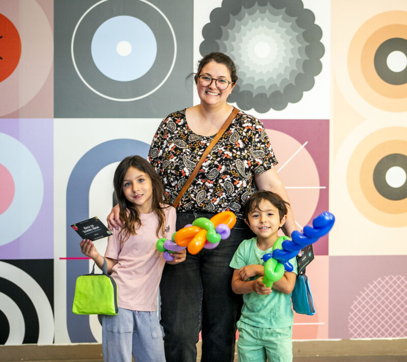 Olive, 6, Banner, 4, and Polly Quesada enjoy balloon animals during the Valencia Town Center "Back-to-School Bash" on Saturday, Aug. 9, 2025. Habeba Mostafa/ The Signal