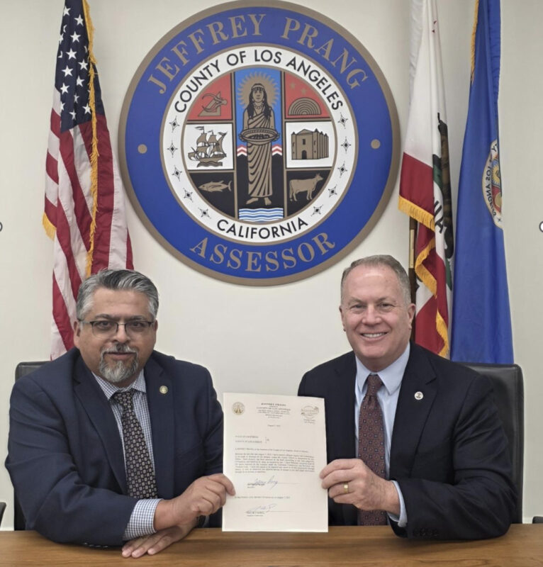 Los Angeles County Auditor-Controller Oscar Valdez (left) and Assessor Jeff Prang finalize the official transfer of the 2025 Assessment Roll, which reflected more than $2 trillion in net value. Photo Courtesy of the Los Angeles County Assessor's Office.