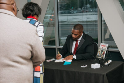 Saugus High School graduate David Doyle signs copies of his novel, "Parker," at a recent signing event. Courtesy photo.