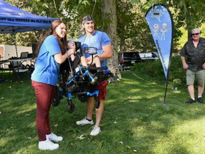 Clockwise from left: Brittany Markham, Brock Markham and their 6-year-old Damien Markham, who’s strapped into the flying rig, prepare for flight at a private residence in Newhall, Aug. 14, 2025. Michael Picarella/The Signal