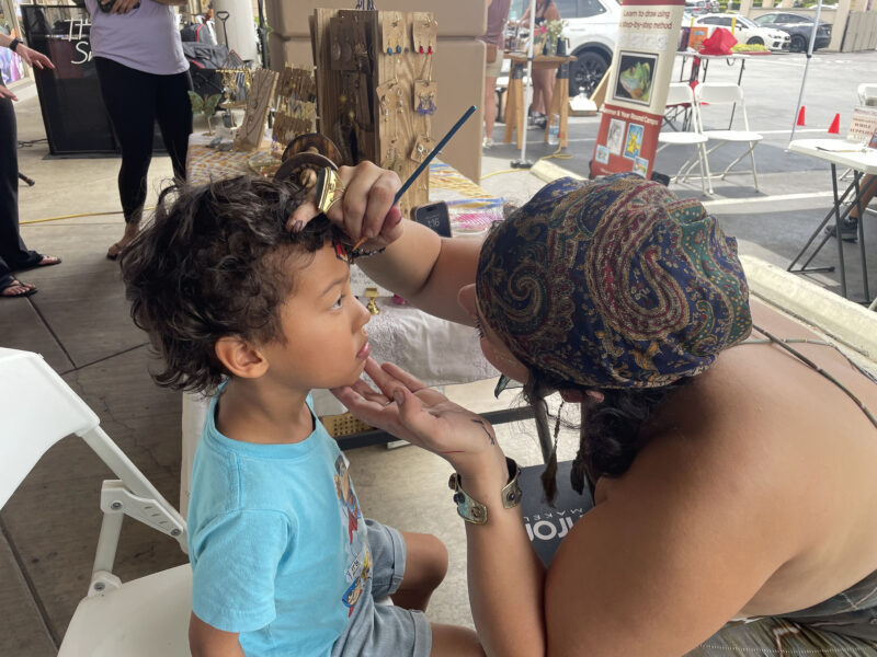 Michelle Keshk (R) paints on Kal-el Reddish's face (L), 3, at the WRARE Foundation's "Paws N' Flow" dog adoption event at YogaSix in Stevenson Ranch, Saturday, Aug. 23, 2025. Kamryn Martell/The Signal