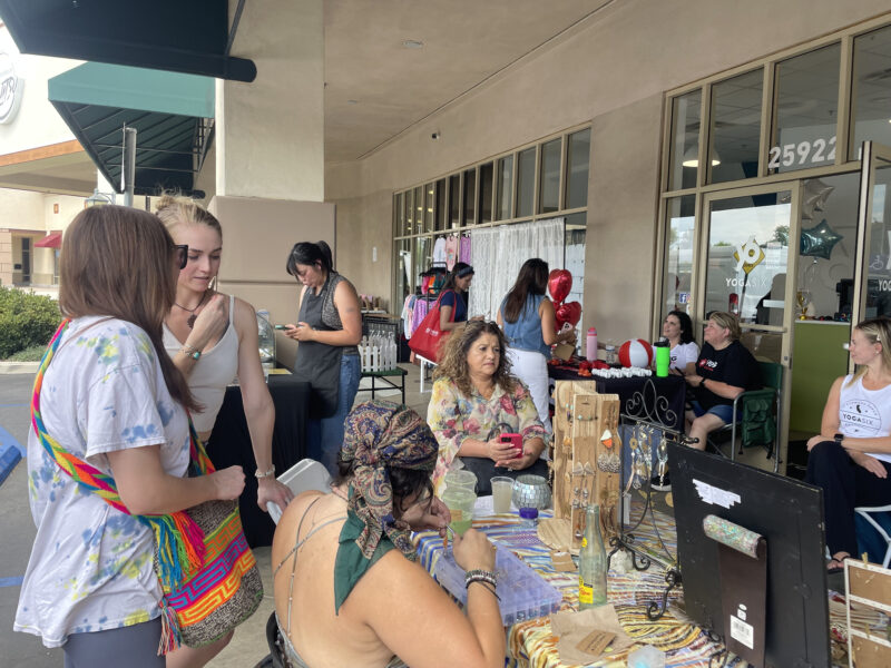 Attendees hang out around the vendor booths at the WRARE Foundation's "Paws N' Flow" dog adoption event at YogaSix in Stevenson Ranch, Saturday, Aug. 23, 2025. Kamryn Martell/The Signal