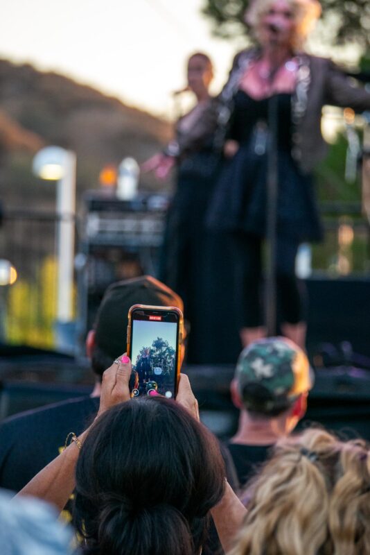 Music fans capture the Blonde Ambition band through their phones as they perfrom some of Madonna’s best hits during “Concerts in the Park” on Saturday Aug. 23, 2025 at Central Park in Saugus, Calif. Katherine Quezada/The Signal