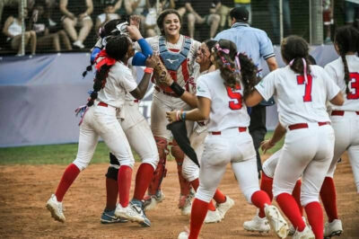 Puerto Rico Celebrates the Team USA victory. Nylah Melendez in catcher vest (center) with her left arm around Naima Melendez. Photo courtesy of WBSC .