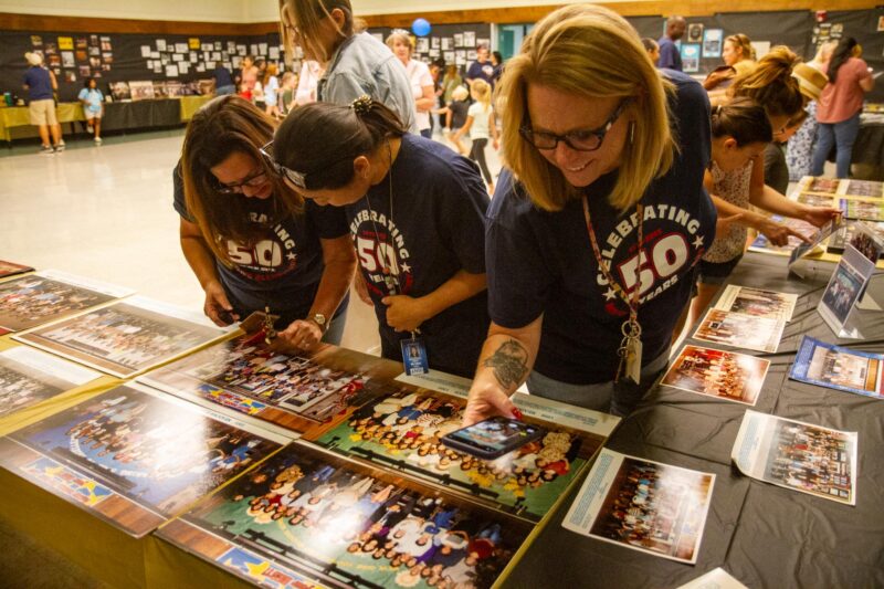 Meadows Elementary teachers and staff Melanie Musella (front), Sarah Yuhan (center) and Sheldy Levine look through past photos during the 50th birthday of Meadows on Sept. 5, 2025. Katherine Quezada/The Signal
