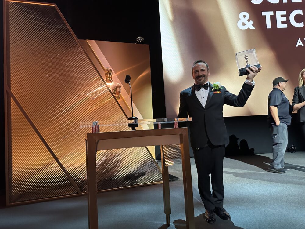 Jayson Dumenigo holds up the Academy’s award for achievement in science and engineering in the David Geffen Theater at the Academy Museum of Motion Pictures in Los Angeles, April 2025. Photo courtesy of Jayson Dumenigo