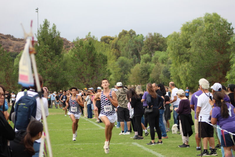Hart boys’ cross-country runners Samuel Aina (581) and Nicolas Zamora (587) sprinting towards the finish line during the 2025 Foothill League Meet #1 at Central Park on September 27, 2025. Ryan Romero/The Signal