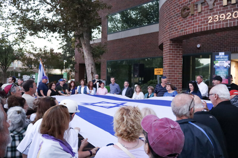 Attendees sing songs while holding the Israeli flag at the "October 7th" memorial at the City of Santa Clarita City Hall, Sunday, Oct. 5, 2025. Kamryn Martell/The Signal