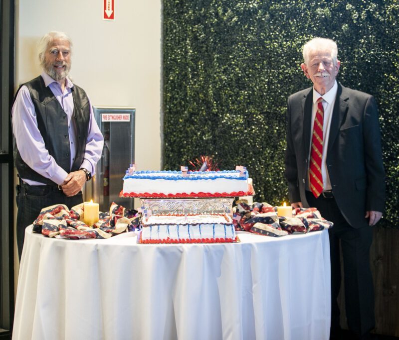 Vietnam Veterans of America, Chapter #355 Secretary Jerry Rhodes, left, and Vice President RJ Kelly stand alongside a custom cake made to celebrate the 250-year anniversary of U.S. armed forces during "Commitment to Freedom" at Bella Vida on Saturday, Oct. 4, 2025. Habeba Mostafa/ The Signal