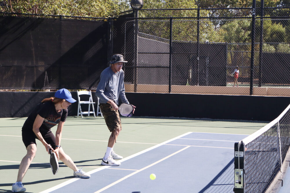 Bonnie Mahler (L) and Steve Rusk (R) try to hit the ball back to the other side of the court at The Michael Hoefflin Foundation “Paddle for the Battle” pickleball fundraiser at The Paseo Club in Valencia, Calif., Sunday, Oct. 12, 2025. Kamryn Martell/The Signal